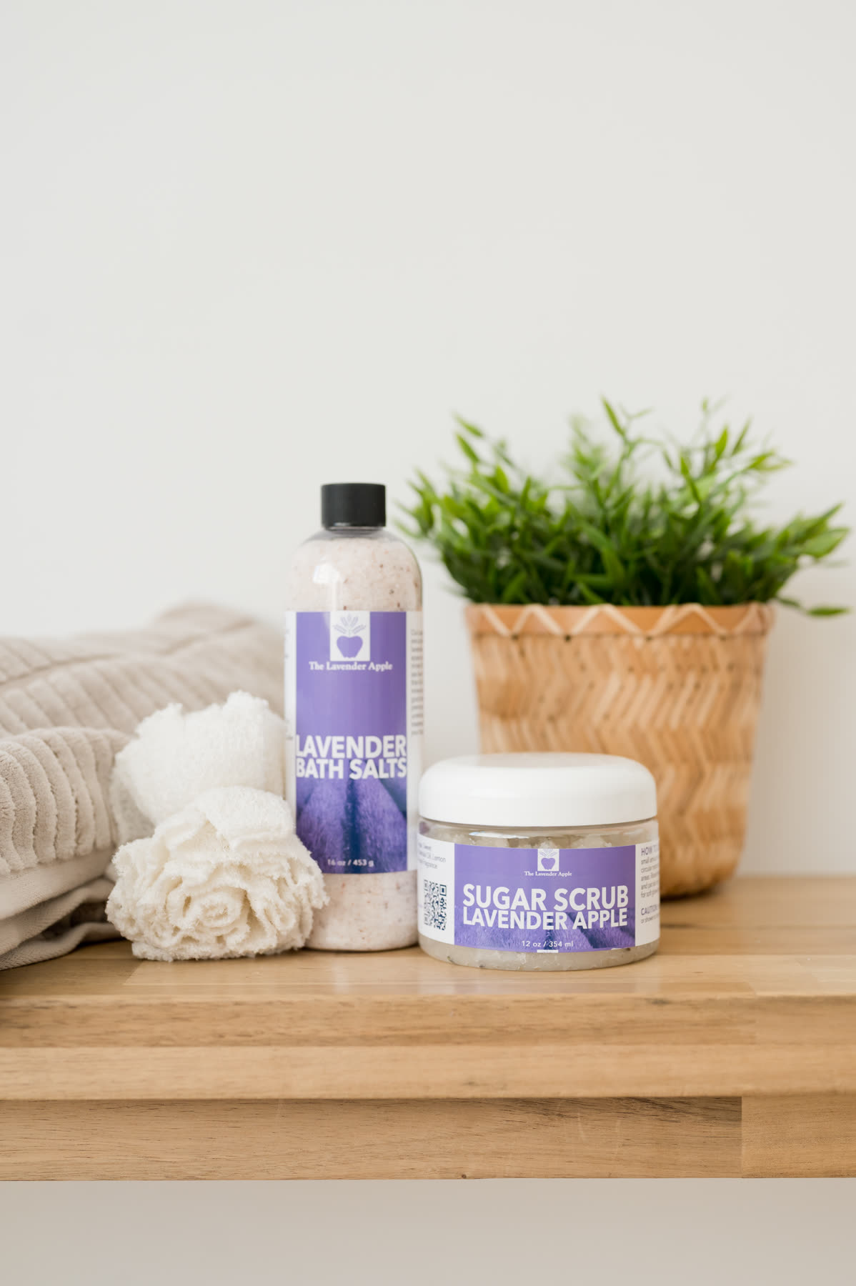 Lavender bath salts and sugar scrub on a wooden shelf